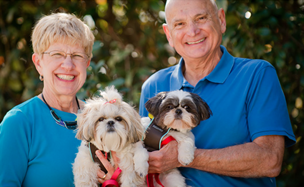 Elderly man and woman holding their pets