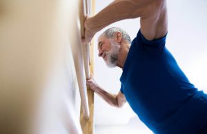man doing push-ups against the wall